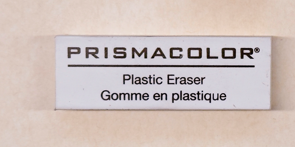 Photograph of a white vinyl eraser on a paper background.